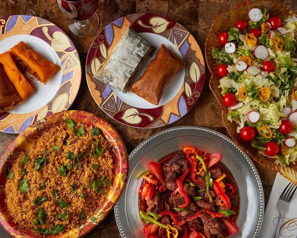 Una mesa con pasteles, arroz, ensalada y carne guisada / A table with pasteles, rice, salad and stewed meat